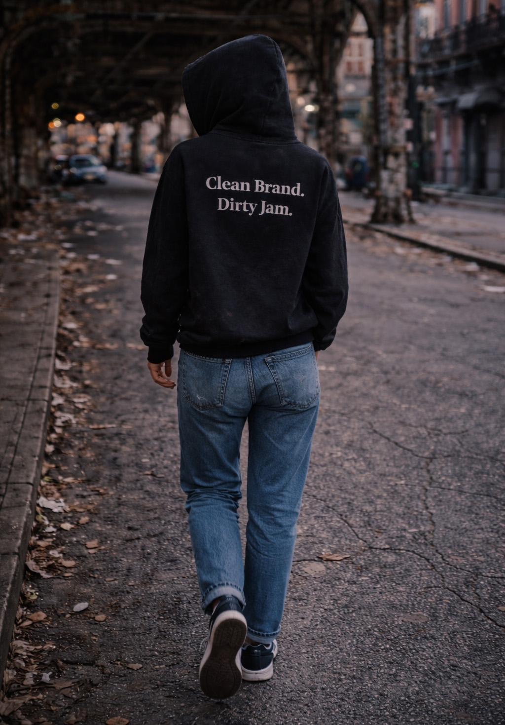 Swearjam black hoodie photographed from behind — 'Clean Brand. Dirty Jam.' set in a serif on the back